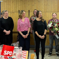 Bürgermeisterkandidat Michael Gradl (rechts) und SPD-Vorsitzender Johannes Ambros bedanken sich mit Blumen bei „Nackad sind i niad“ (von links: … Daniela Ludwig und Carola Helm) für den tollen Abend.